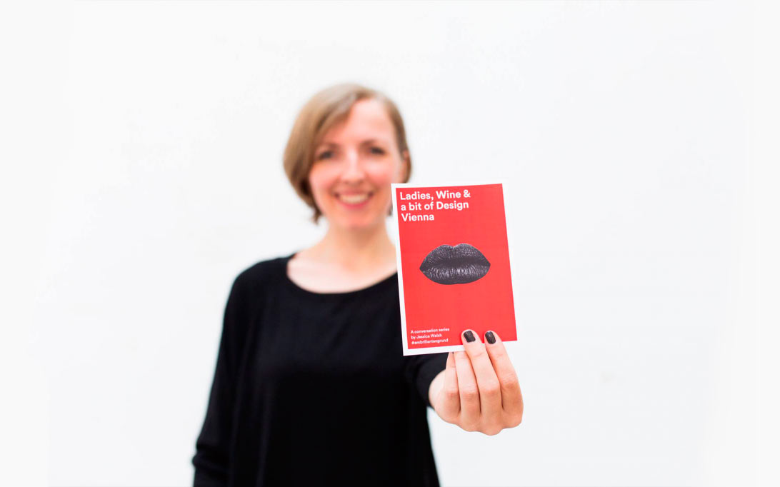 Mujer mostrando el flyer para las charlas Ladies. wine & design Vienna